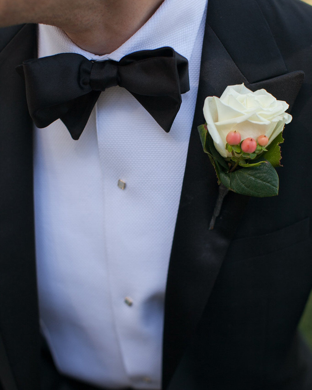 Close up of model wearing mens tuxedo shirt by Luxire in white with black bow tie