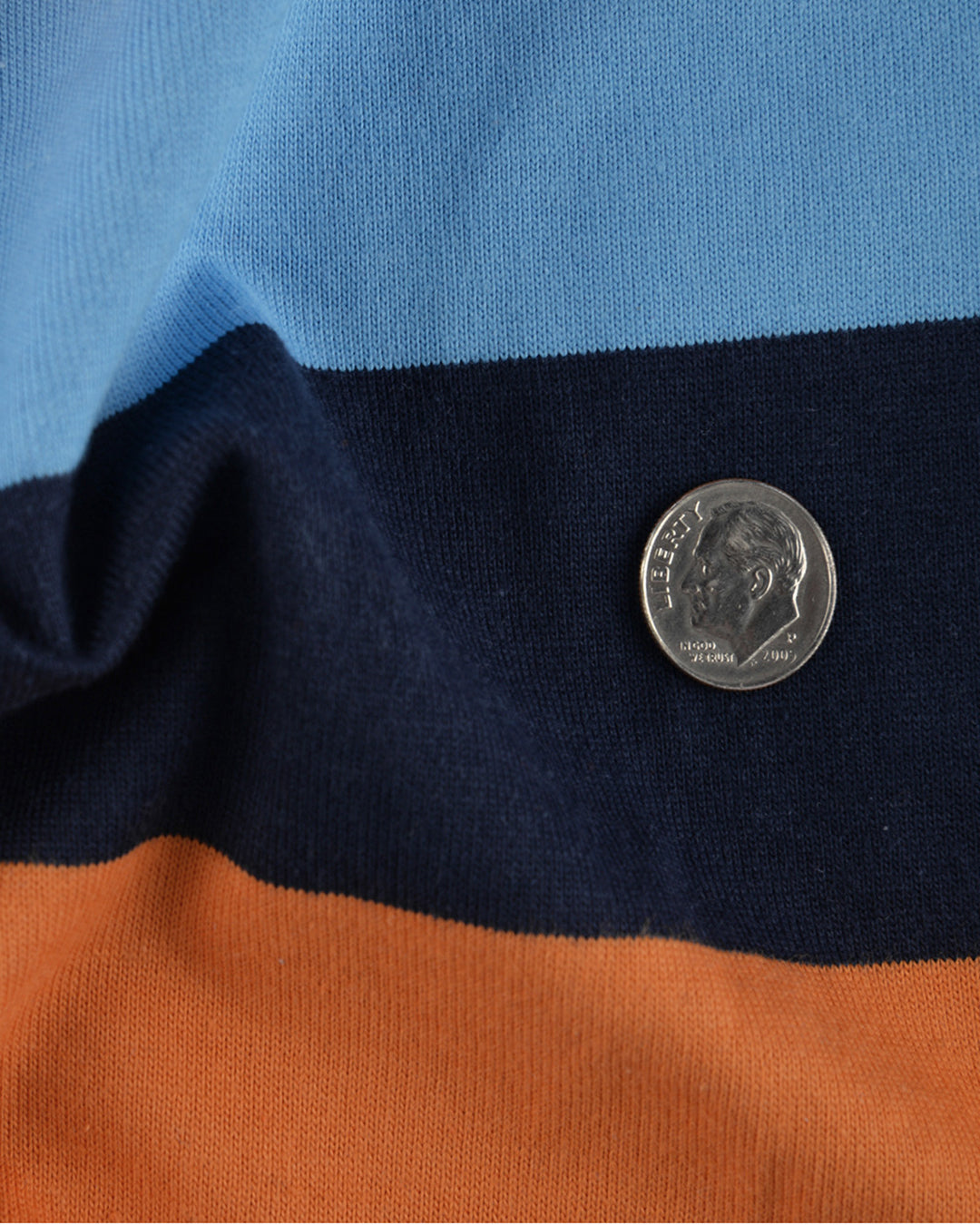 Close up of the custom oxford polo shirt for men by Luxire with navy blue and orange stripes