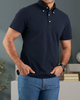 Model wearing the custom oxford polo shirt for men by Luxire in navy hands in pockets 2